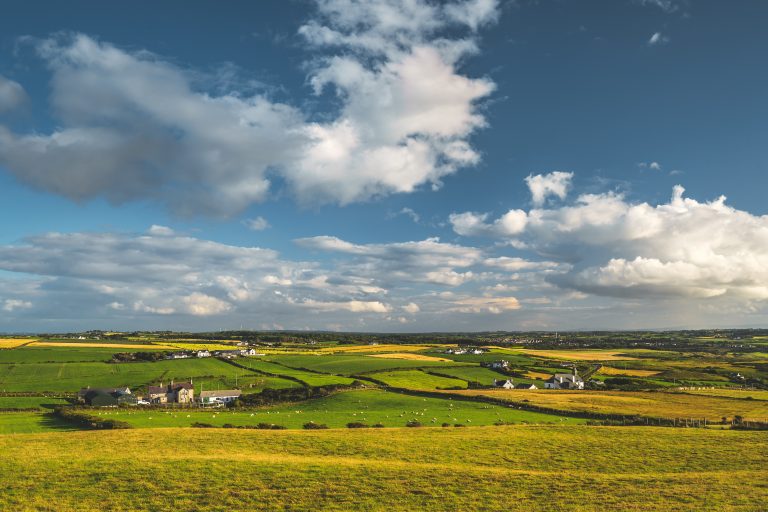 Irish countryside panorama. Green field, blue sky.